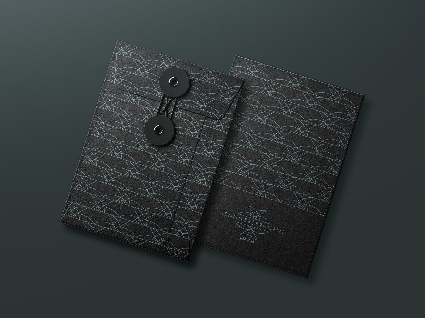 Jacober Creative envelope design for Realtor Jennifer Brilliant. Black folder with pattern and logo